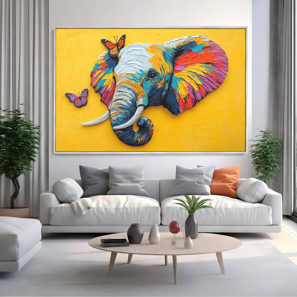 Tablou canvas cu tablou canvas cu elefant colorat si fluturi, in rama de aluminiu argintiu, pe perete intr-un living
